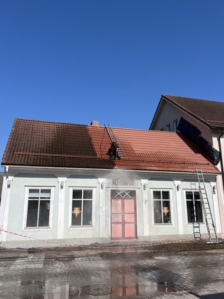 Punase kivikatuse poolik survepesu, et näidata katusepesu efektiivsust katuse välimuse taastamises